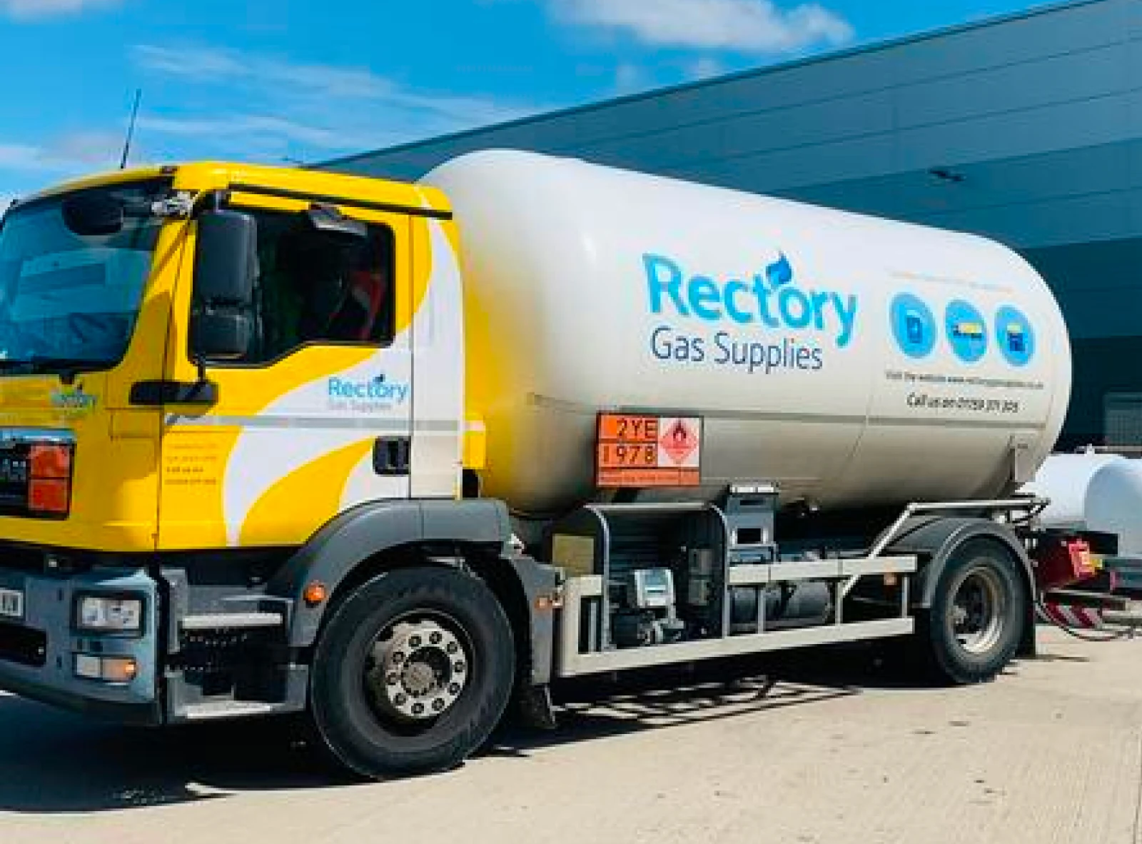 A yellow-cabbed Rectory Gas Supplies bulk LPG tanker parked at a commercial site