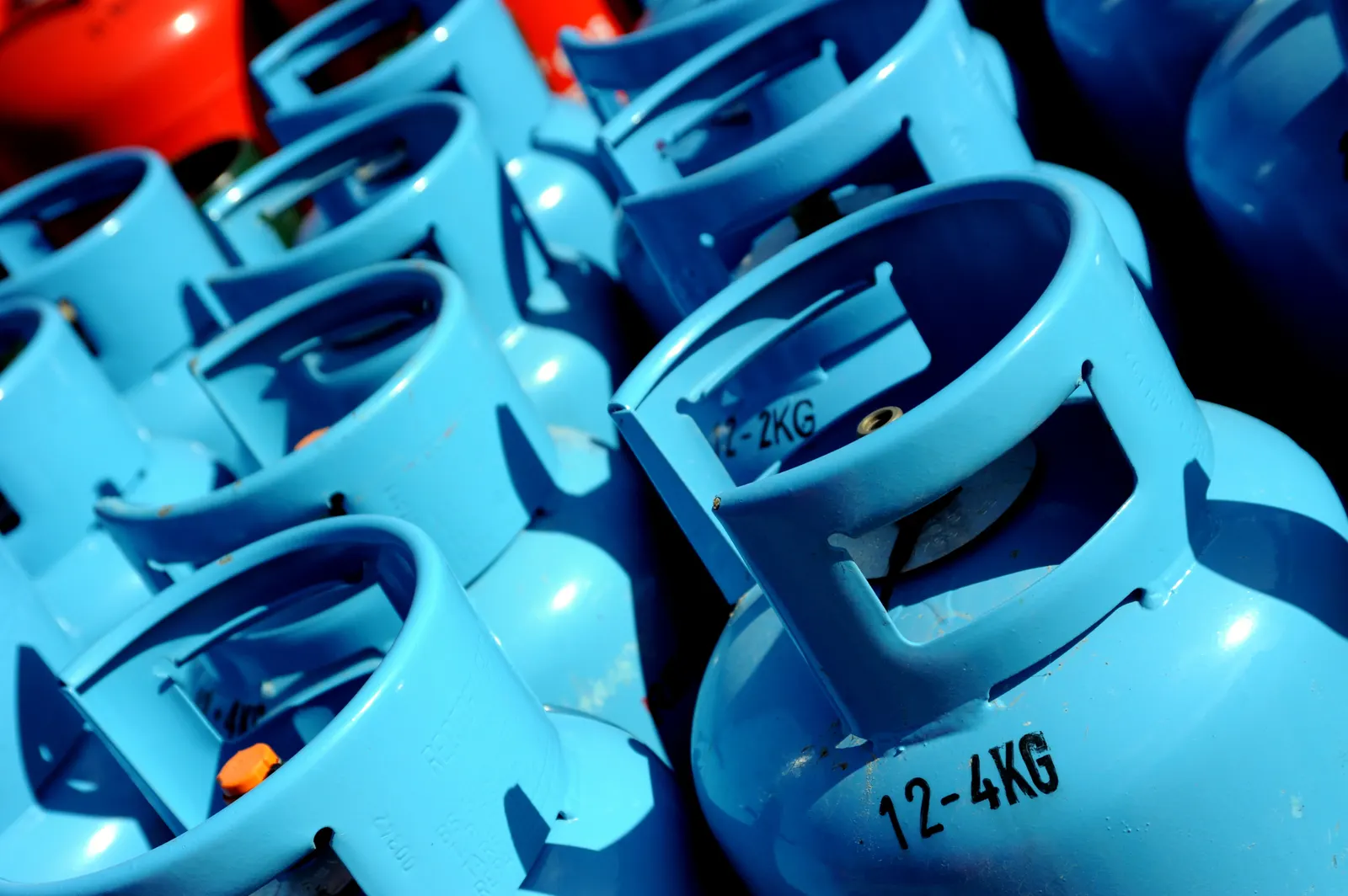 Close-up of blue LPG gas cylinders stacked side by side